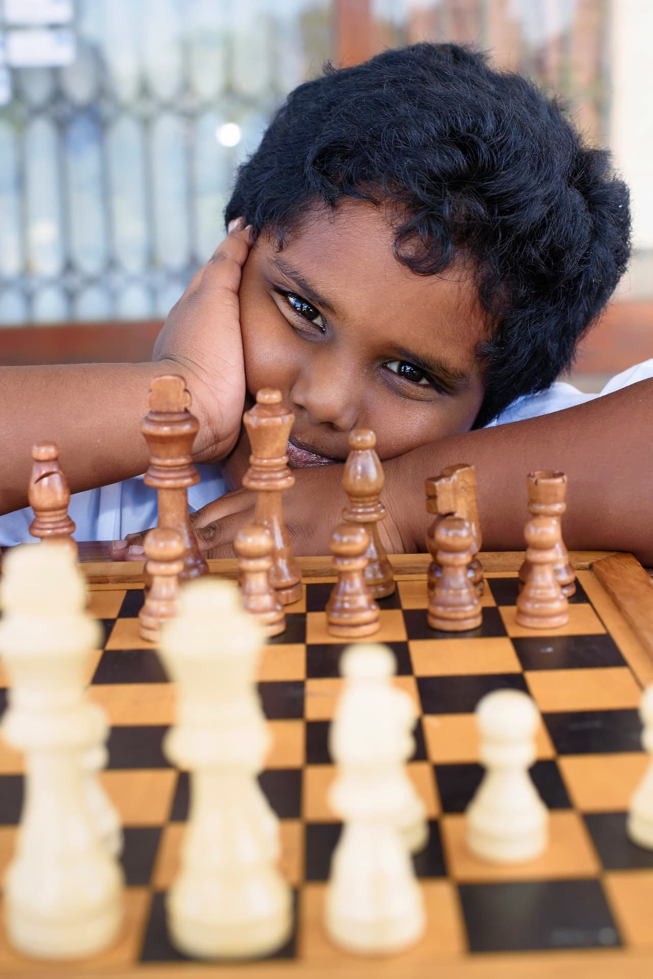 A young chess player concentrating on his next move