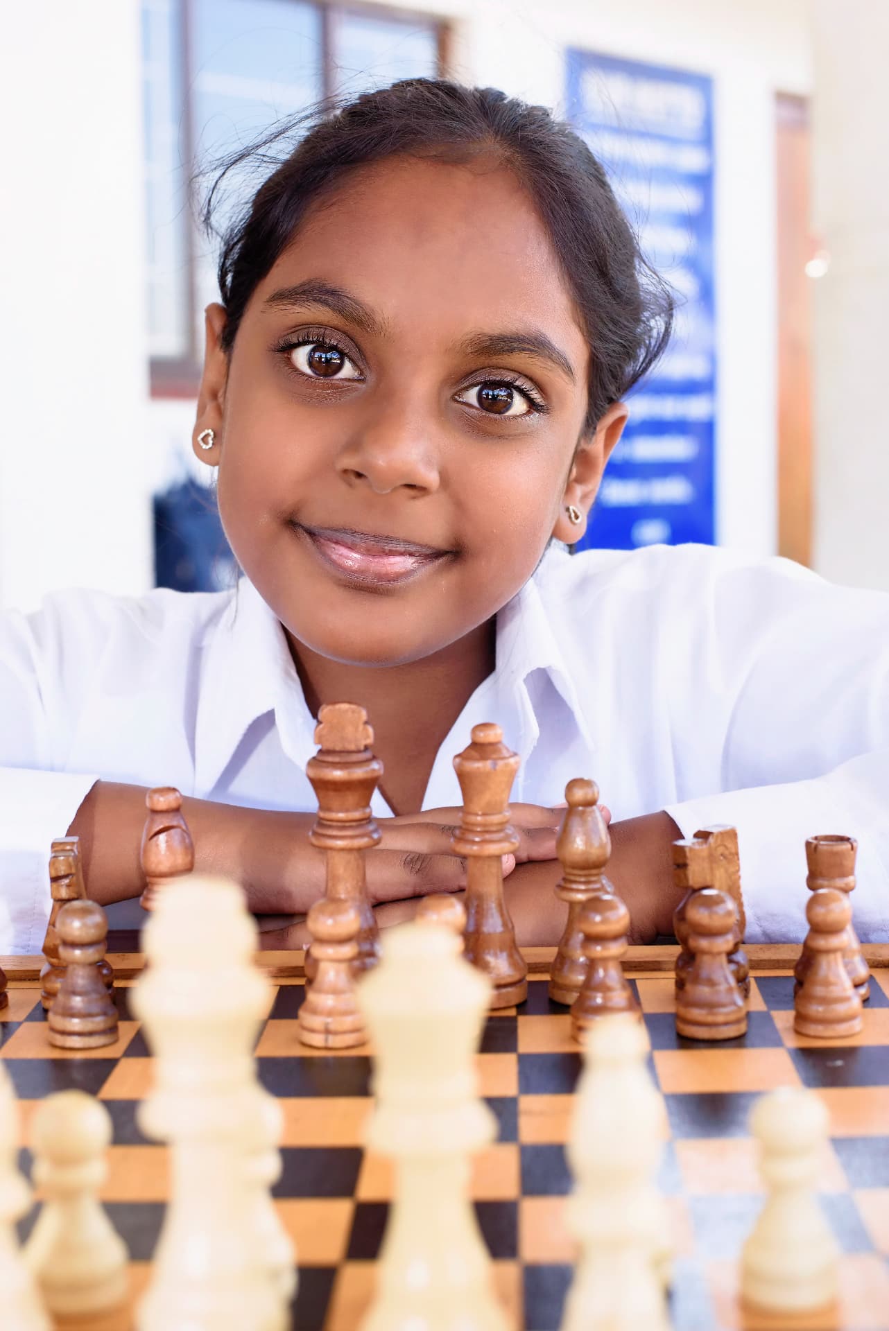 A Harrington pupil smiling behind a chess board