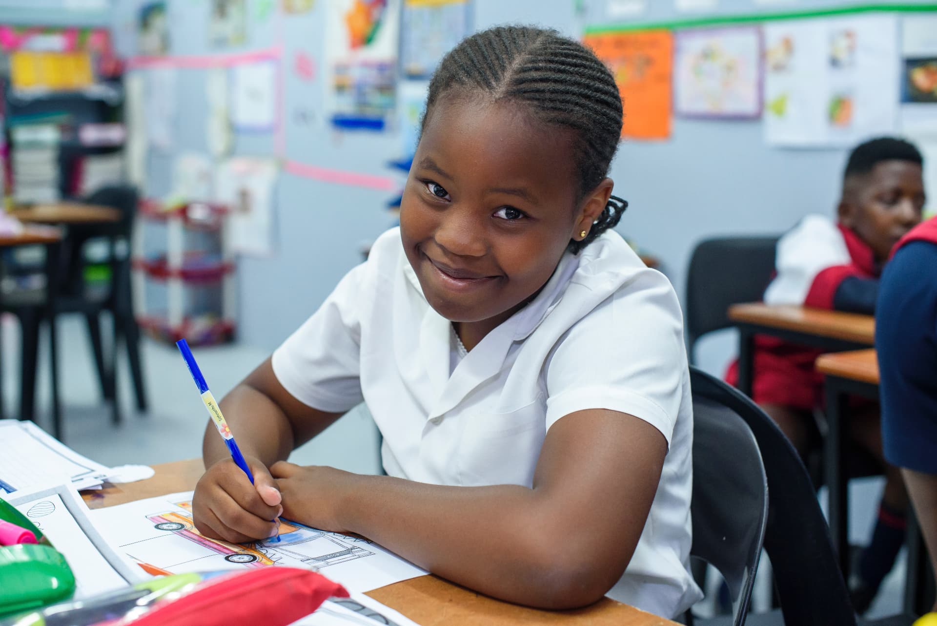 A Harrington learner writing at her desk